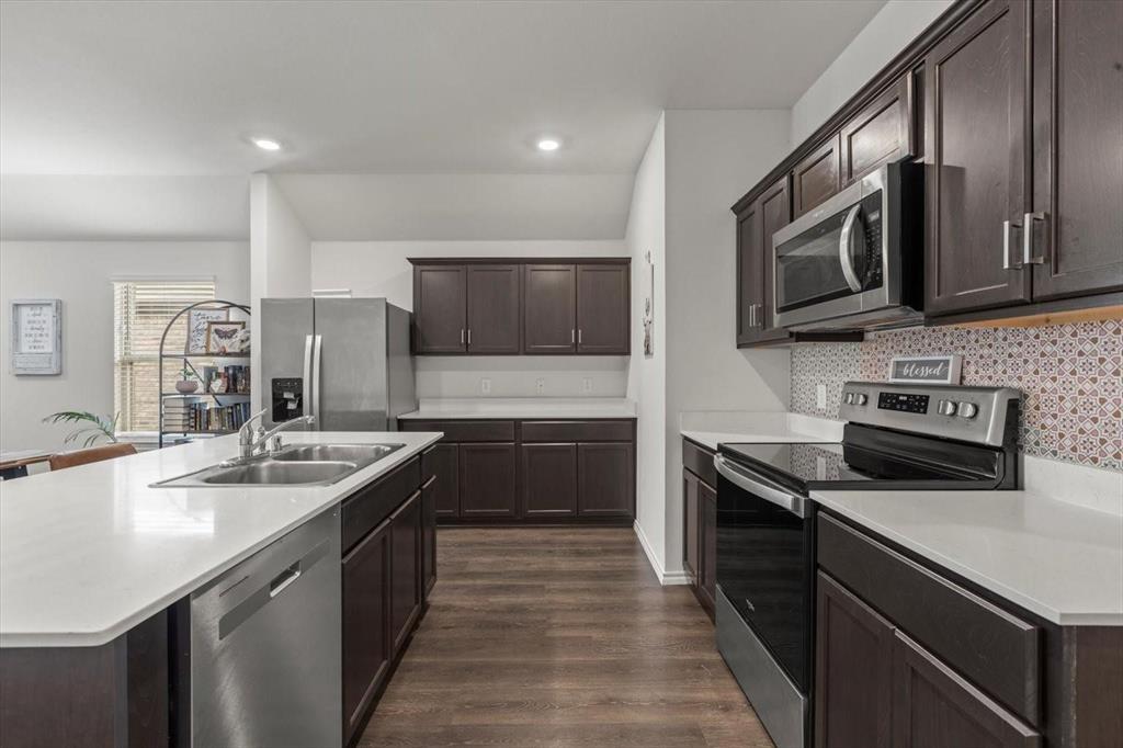113 Keller Road Royse City, TX 75189 - Photo 21 of 25 a kitchen with stainless steel appliances granite countertop a sink a stove top oven a refrigerator with grey cabinets
