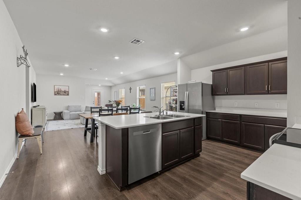 113 Keller Road Royse City, TX 75189 - Photo 23 of 25 a kitchen with stainless steel appliances granite countertop wooden cabinets a sink dishwasher a stove and a refrigerator with wooden floor