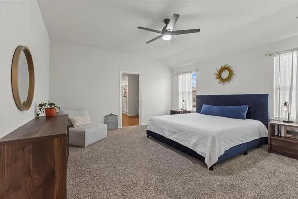 a spacious bedroom with a bed and a chandelier