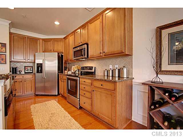 307 Wave Crest Drive, Unit 307 Tega Cay, SC 29708 - Photo 5 of 16 a kitchen with stainless steel appliances granite countertop a refrigerator a stove and a sink