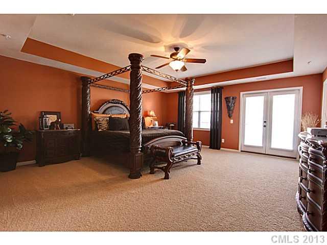 307 Wave Crest Drive, Unit 307 Tega Cay, SC 29708 - Photo 7 of 16 a bedroom with a bed and a chandelier