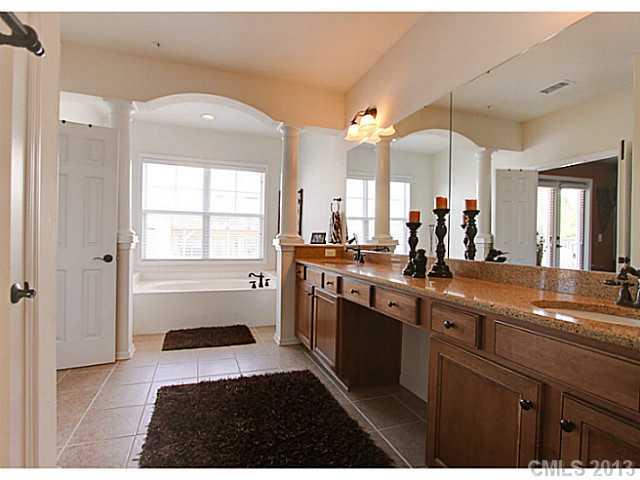 307 Wave Crest Drive, Unit 307 Tega Cay, SC 29708 - Photo 8 of 16 a spacious bathroom with a double vanity sink a large mirror and a bathtub