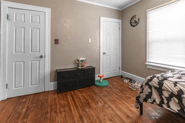 a bedroom with a bed and wooden floor
