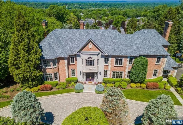 a front view of a house with a yard and potted plants