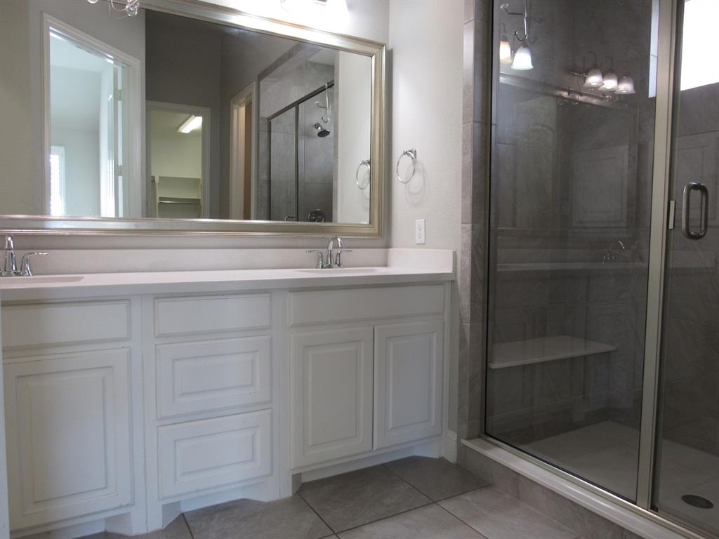 816 Pier Street Little Elm, TX 76227 - Photo 17 of 27 Full bathroom featuring double vanity, a stall shower, and light tile patterned flooring