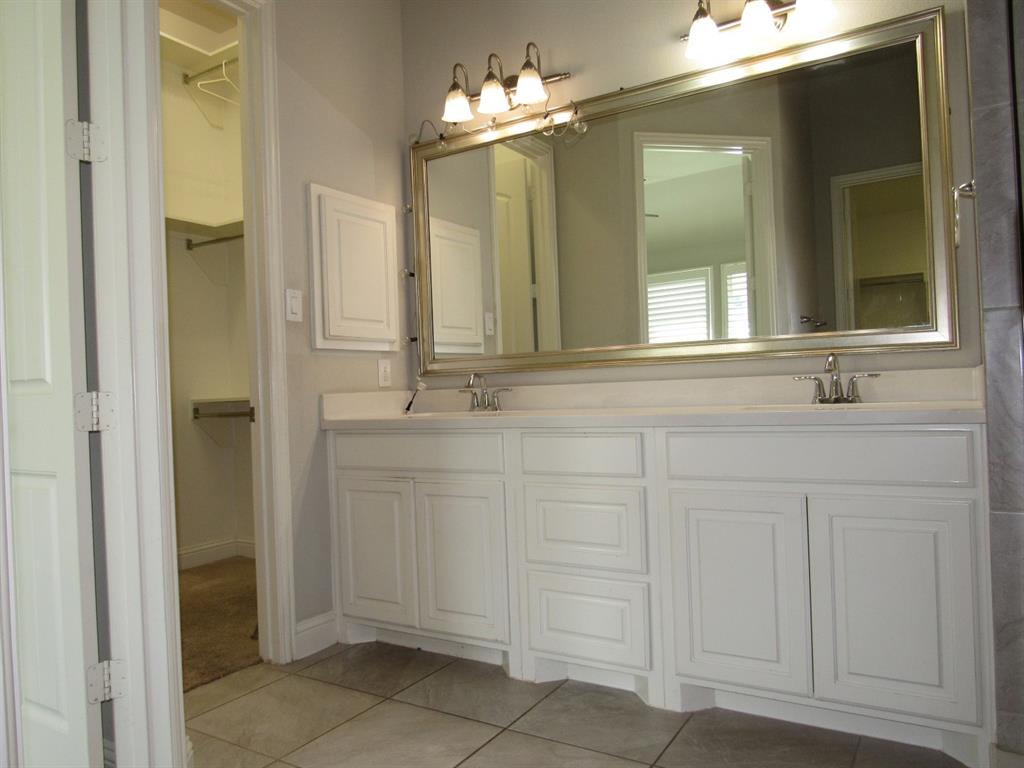 816 Pier Street Little Elm, TX 76227 - Photo 19 of 27 Full bath with double vanity, a spacious closet, and light tile patterned flooring