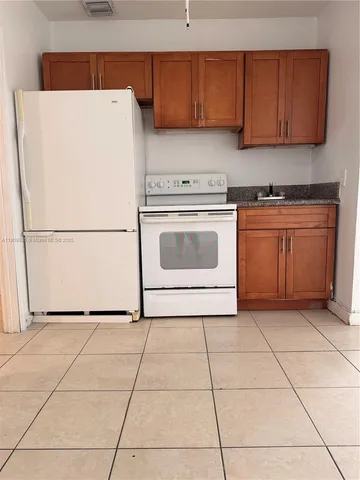 a kitchen with a cabinets and white appliances