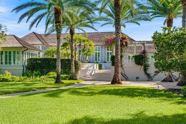 a front view of a house with garden and trees