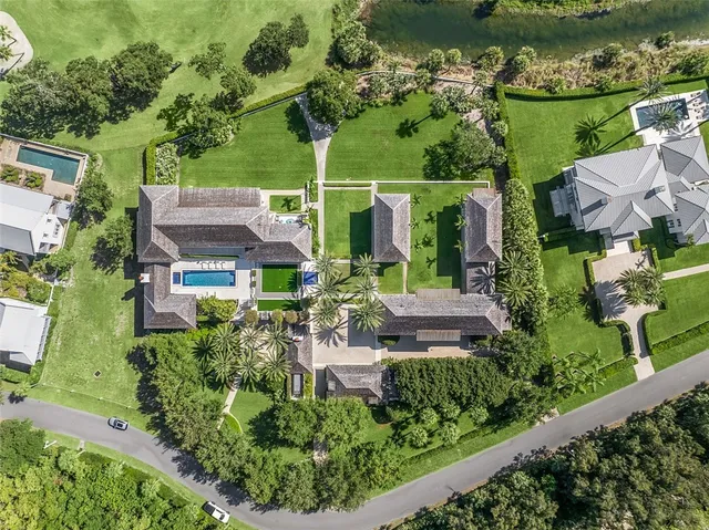 an aerial view of a house with outdoor space swimming pool tennis courts and ocean view