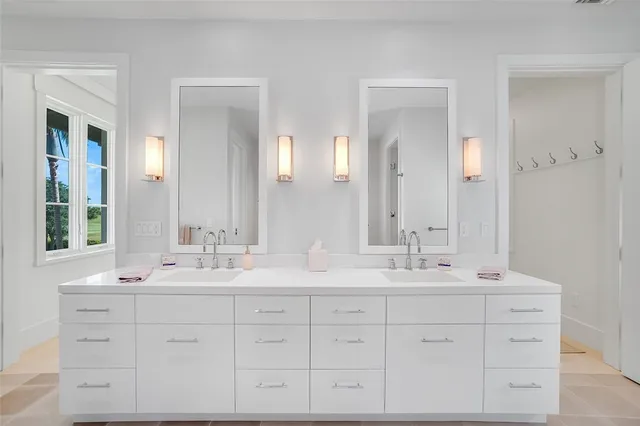 a bathroom with double sink and a mirror