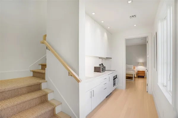 a kitchen with white cabinets and sink