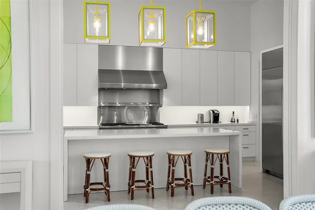 a kitchen with stainless steel appliances a table and chairs in it