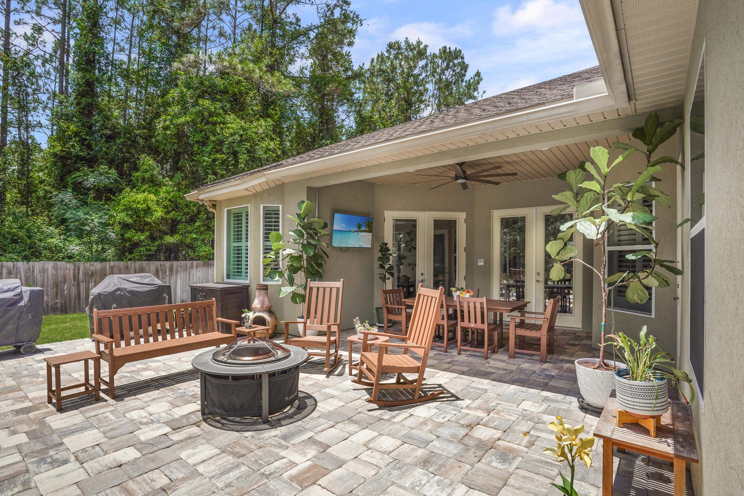 1308 Acorn Ridge Court St. Augustine, FL 32092 - Photo 41 of 47 a view of a patio with table and chairs potted plants and floor to ceiling window