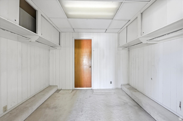 292 West 400 South Springville, UT 84663 - Photo 21 of 37 Room featuring white vertical paneling, a drop ceiling with fluorescent lighting, and a wood-finish door