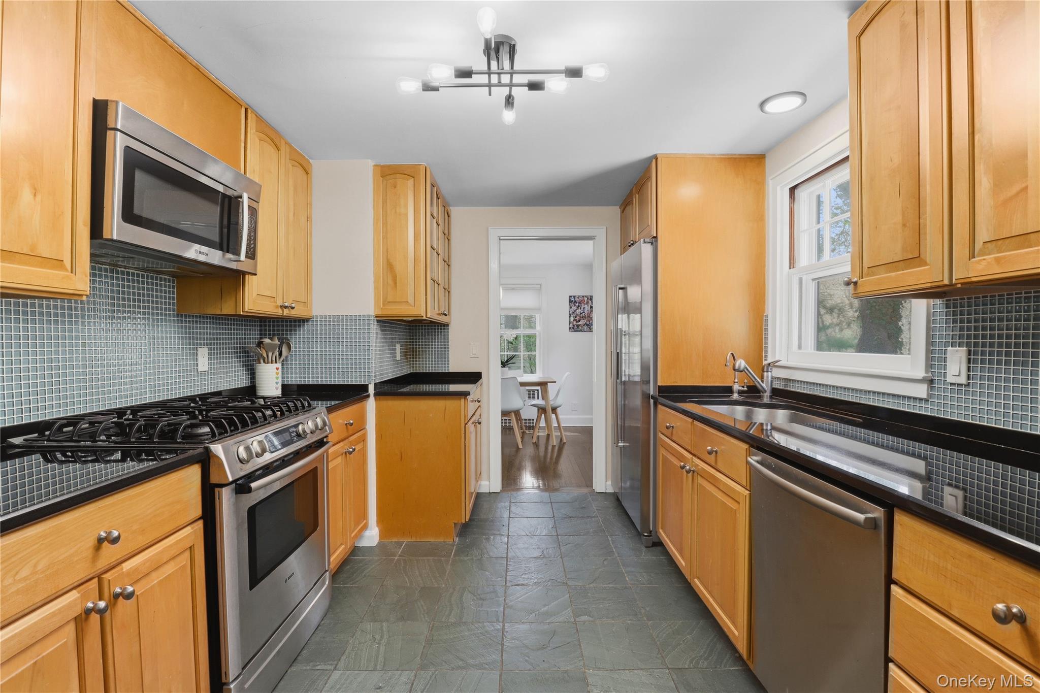 576 Old Post Road Bedford, NY 10506 - Photo 16 of 29 a kitchen with stainless steel appliances granite countertop a stove a sink and a microwave