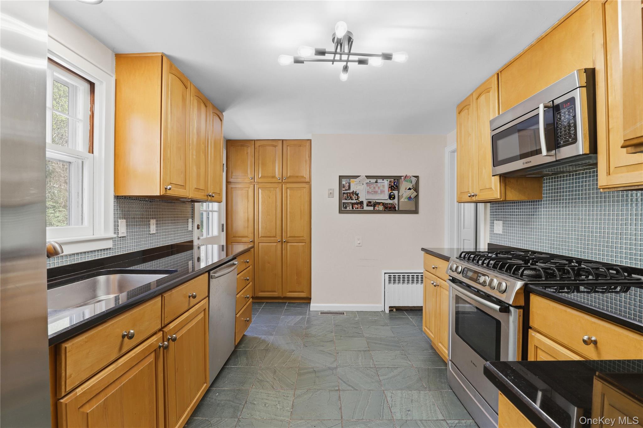576 Old Post Road Bedford, NY 10506 - Photo 17 of 29 a kitchen with stainless steel appliances granite countertop a stove a sink and a microwave