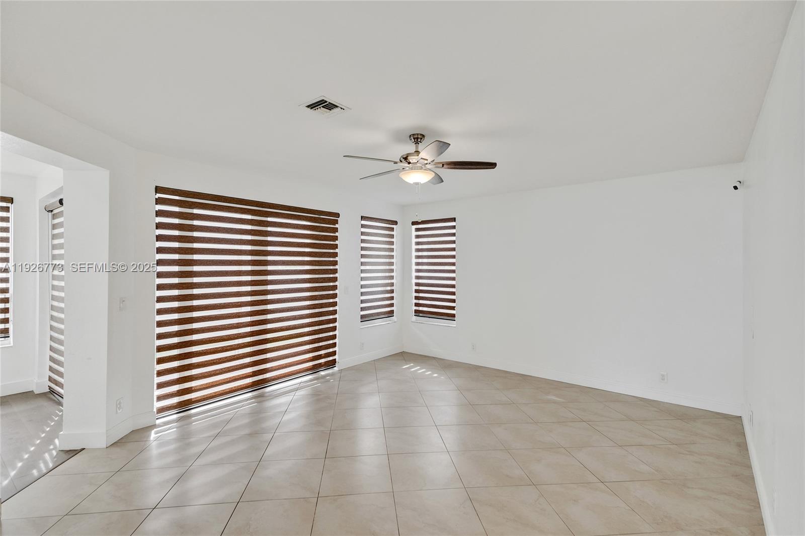 740 Cypress Pointe Drive East Pembroke Pines, FL 33027 - Photo 11 of 46 an empty room with windows and ceiling fan