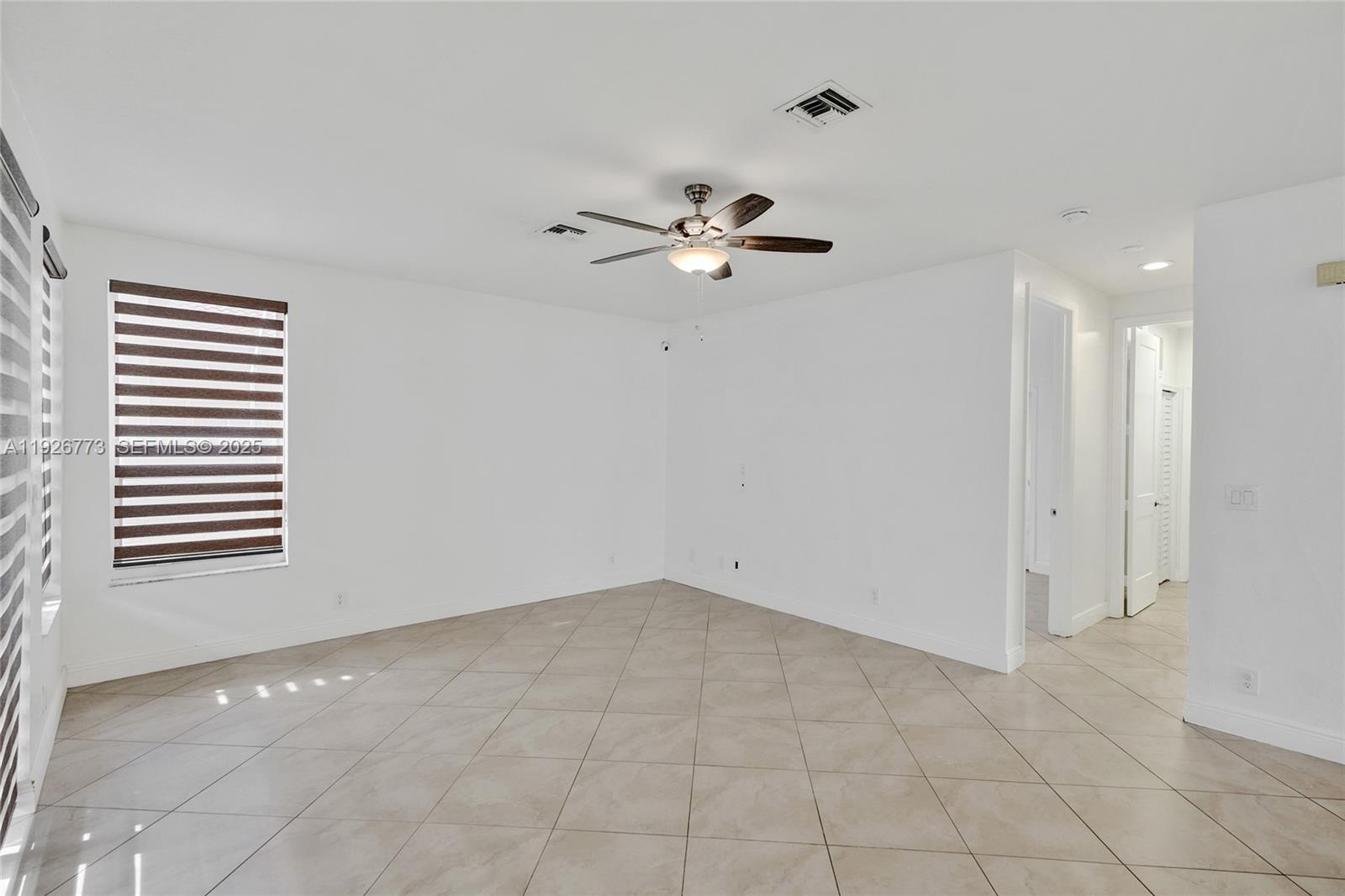 740 Cypress Pointe Drive East Pembroke Pines, FL 33027 - Photo 13 of 46 a view of an empty room with a ceiling fan and a window