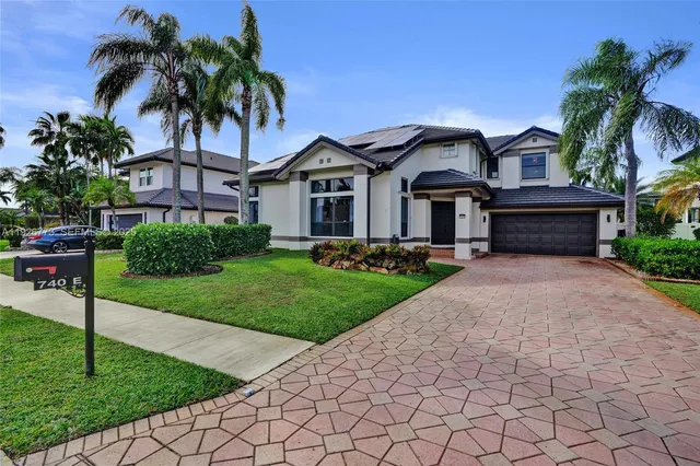 a front view of a house with a yard and potted plants