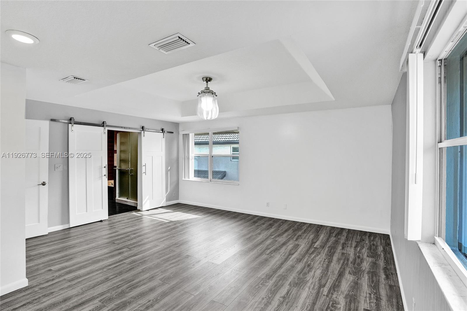 740 Cypress Pointe Drive East Pembroke Pines, FL 33027 - Photo 22 of 46 a view of an empty room with wooden floor and windows