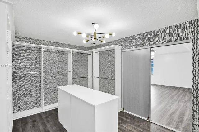 a view of a refrigerator in kitchen and an empty room