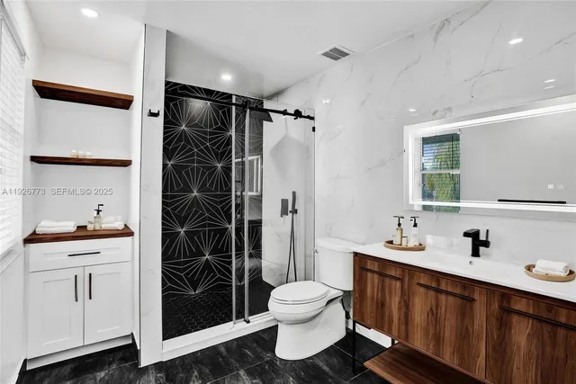 a bathroom with a double vanity sink toilet and shower