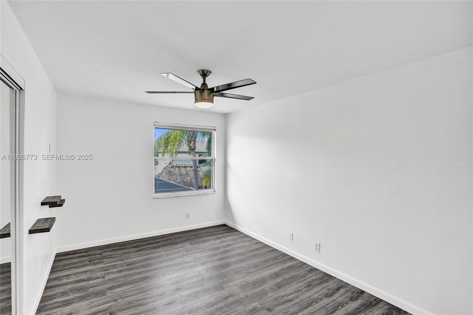 740 Cypress Pointe Drive East Pembroke Pines, FL 33027 - Photo 34 of 46 a view of an empty room with wooden floor and a window
