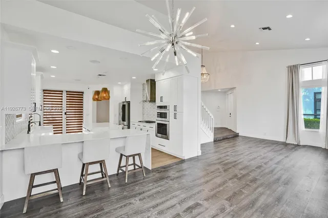 a view of a kitchen with wooden floor and a window