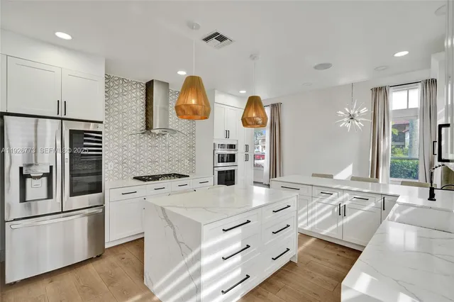 a kitchen with stainless steel appliances granite countertop a sink and a stove