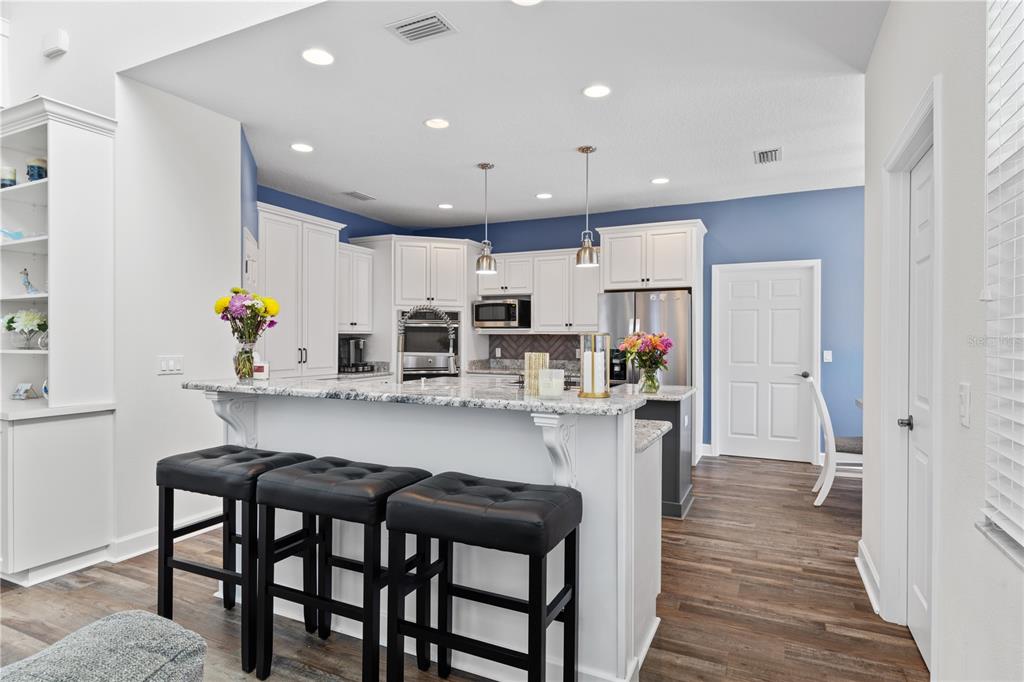 16948 Deer Island Road Tavares, FL 32778 - Photo 9 of 67 a kitchen with stainless steel appliances a dining table chairs refrigerator and sink