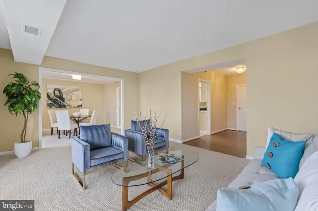 a kitchen with stainless steel appliances kitchen island granite countertop a refrigerator a stove a microwave oven a dining table and chairs with wooden floor