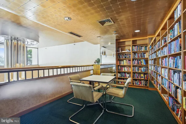 a living room with furniture and a book shelf