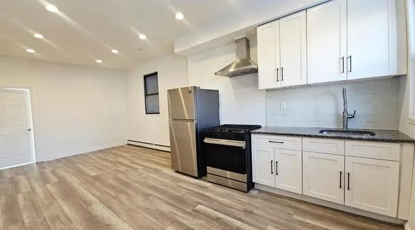 a kitchen with granite countertop white cabinets and stainless steel appliances