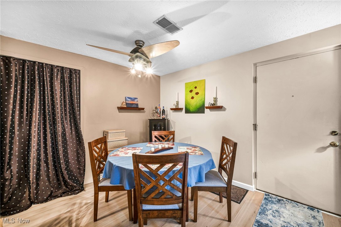 4750 Oak Point Road, Unit 304 Lorain, OH 44053 - Photo 14 of 29 Dining space with a textured ceiling, light wood-type flooring, and ceiling fan