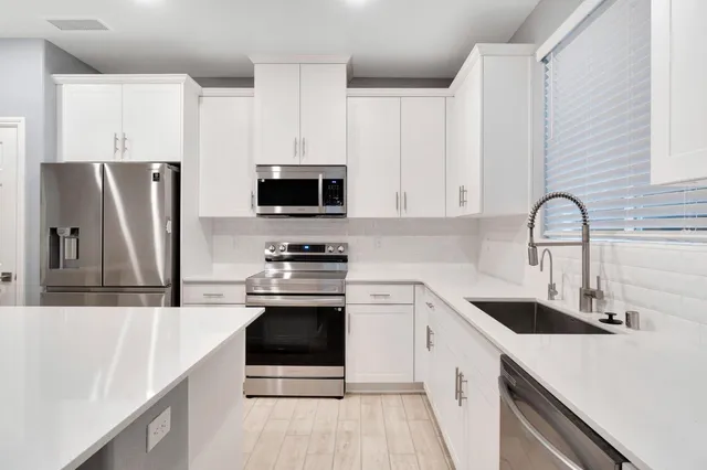 a kitchen with a sink cabinets and window