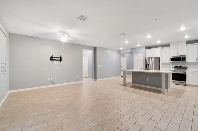 a kitchen with kitchen island a sink stainless steel appliances and cabinets