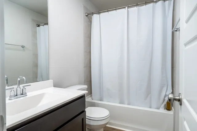 a bathroom with a sink a toilet and shower curtain