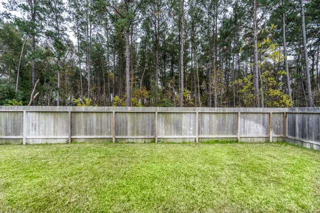 a view of backyard with a fence