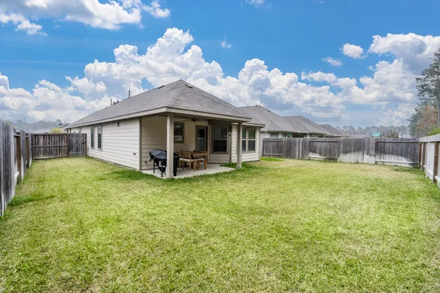 a view of a house with backyard and porch