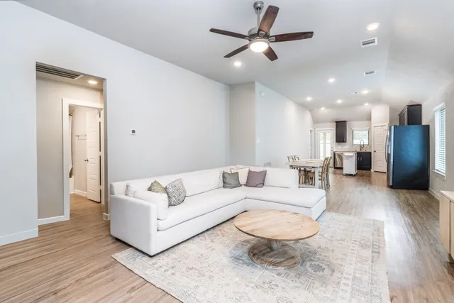 a living room with furniture and a view of kitchen