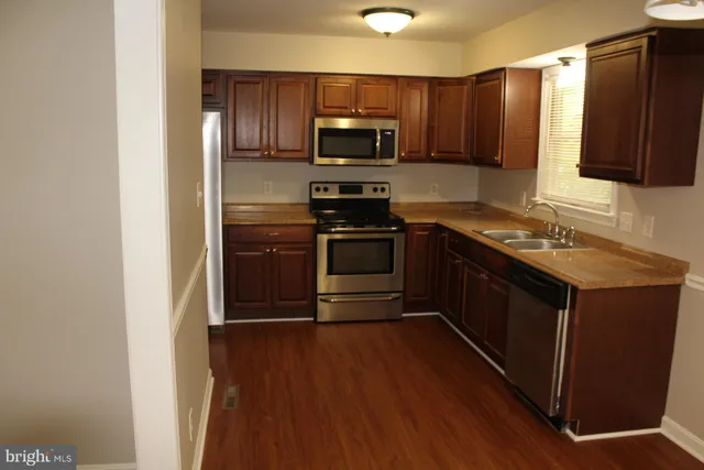 a kitchen with granite countertop a stove and a microwave