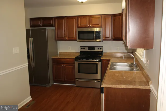 a kitchen with granite countertop stainless steel appliances and wooden cabinets