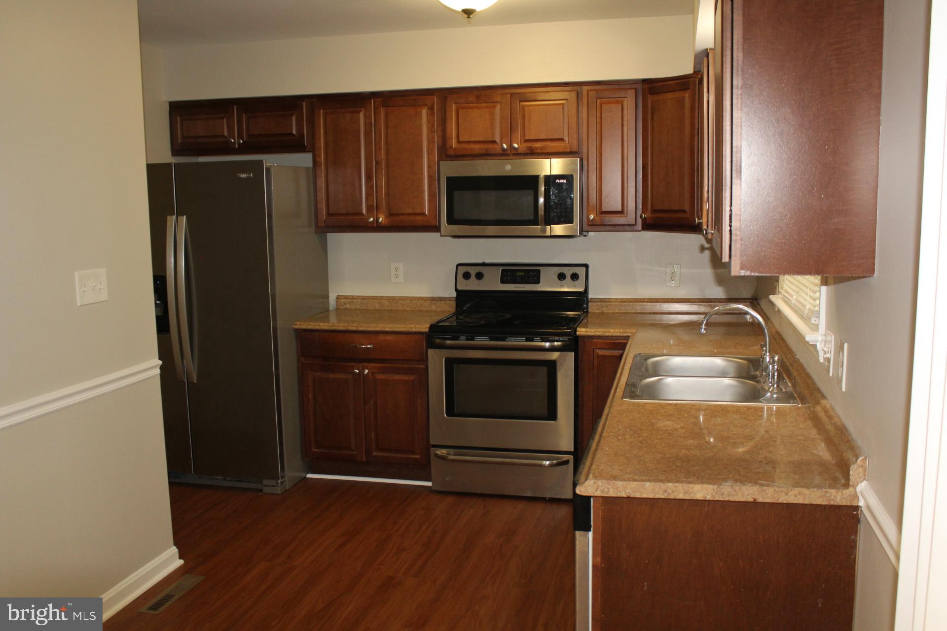 423 Laurel Avenue Fredericksburg, VA 22408 - Photo 10 of 28 a kitchen with granite countertop stainless steel appliances and wooden cabinets