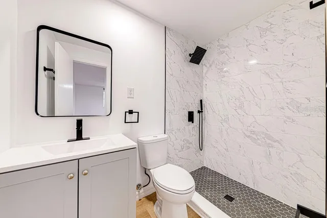 a bathroom with a toilet sink and mirror