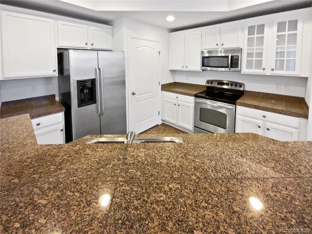 a kitchen with stainless steel appliances a stove a microwave and a refrigerator