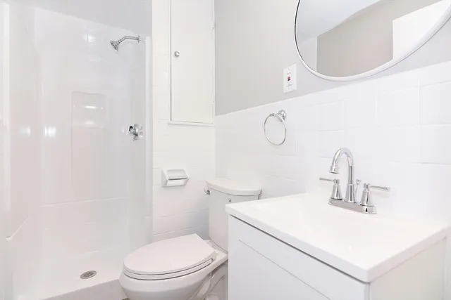 a bathroom with a sink a toilet and shower
