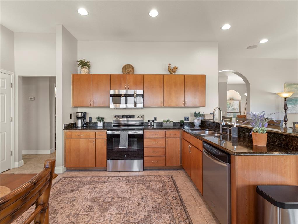 20 Fort Clinch Heights Road Frostproof, FL 33843 - Photo 11 of 38 a kitchen with stainless steel appliances granite countertop a stove a sink and a refrigerator