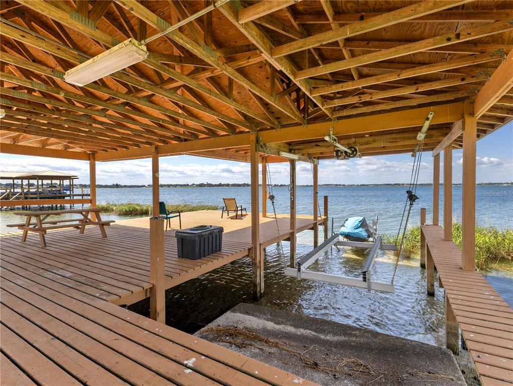 20 Fort Clinch Heights Road Frostproof, FL 33843 - Photo 32 of 38 a view of a patio with lawn chairs and wooden floor