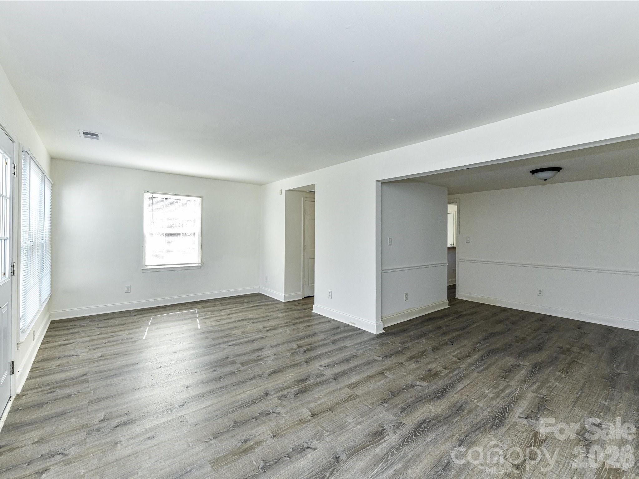 8322 Knights Bridge Road Charlotte, NC 28210 - Photo 11 of 37 an empty room with wooden floor and windows