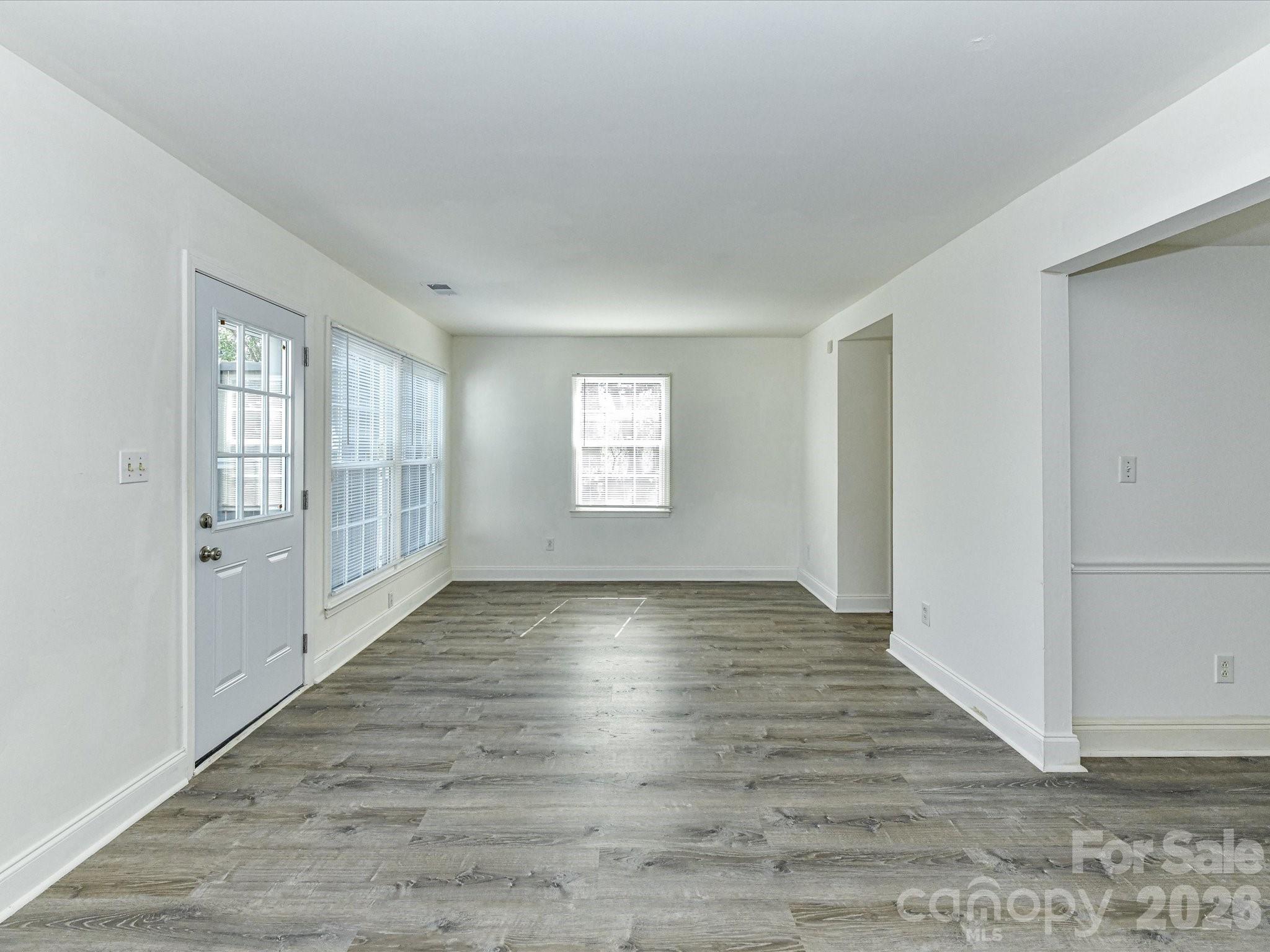 8322 Knights Bridge Road Charlotte, NC 28210 - Photo 12 of 37 an empty room with wooden floor and windows